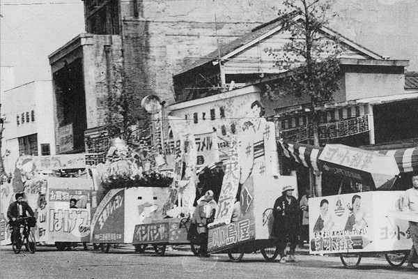 鍛冶町で行われた広告カーニバル。写真左端に「電気のデパート電器堂」と書かれた幕が見える（昭和24年）